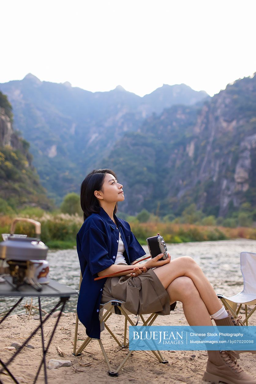 Cheerful young Chinese woman enjoying the beautiful natural scenery