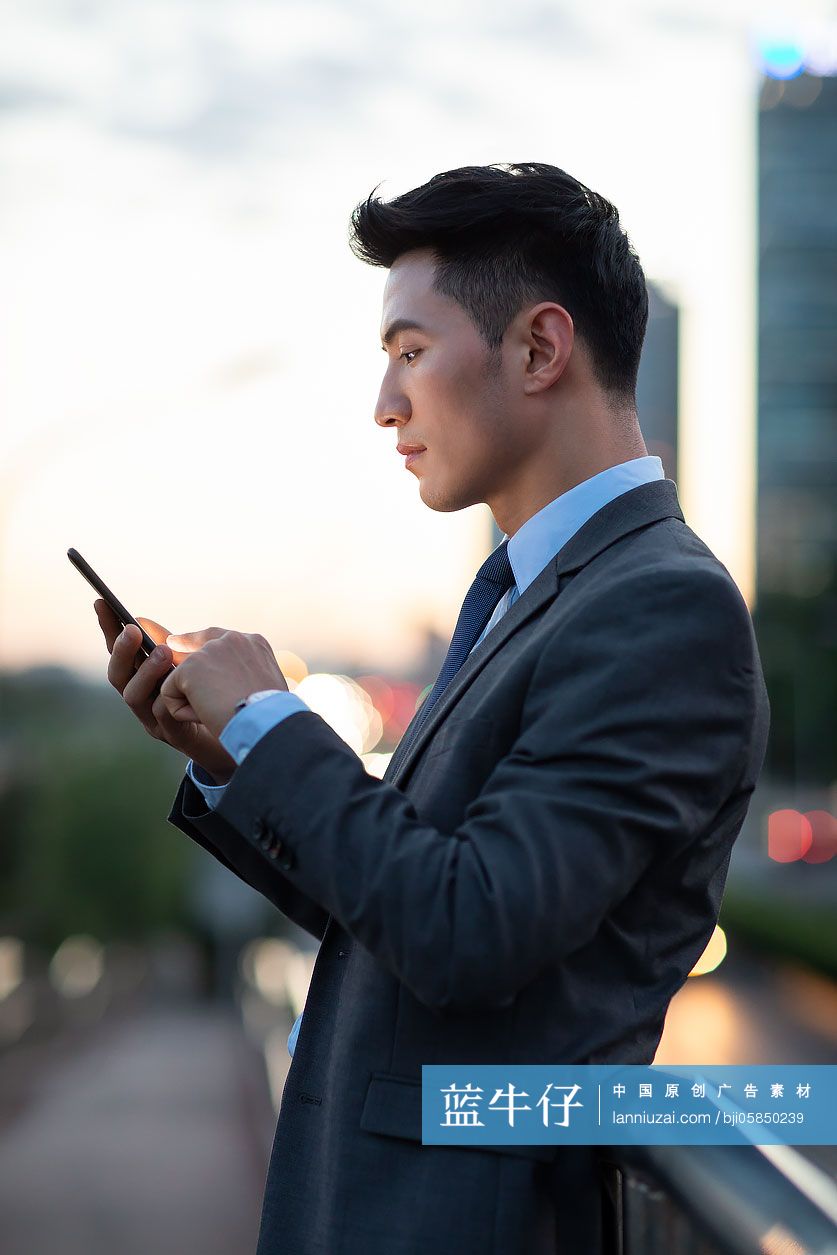 自信的年轻商务男士使用手机