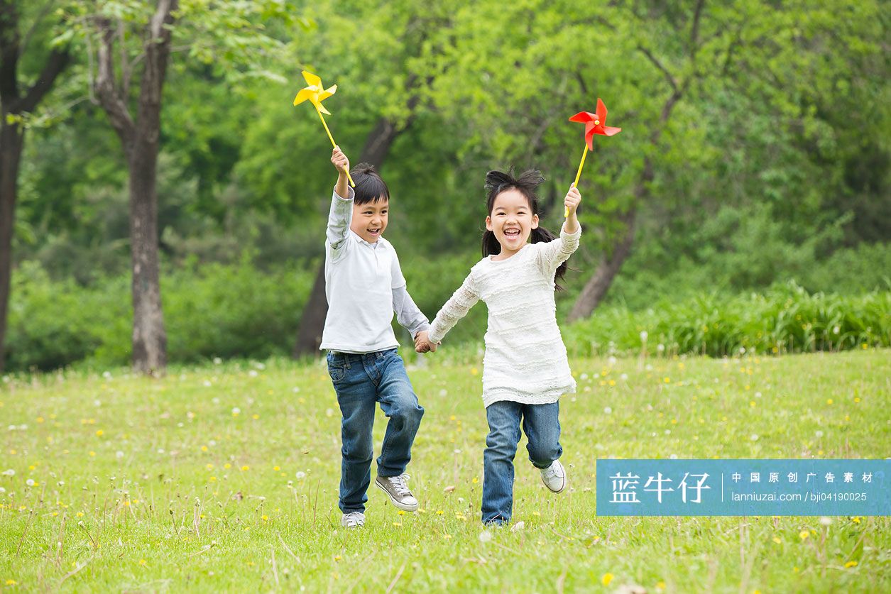 快乐的孩子们在草地上玩纸风车