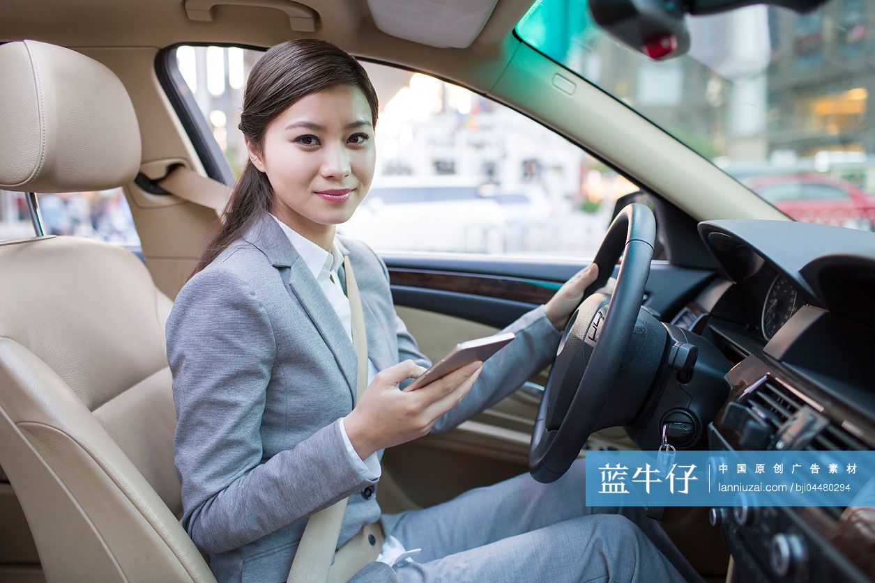 商务女士在车里使用手机