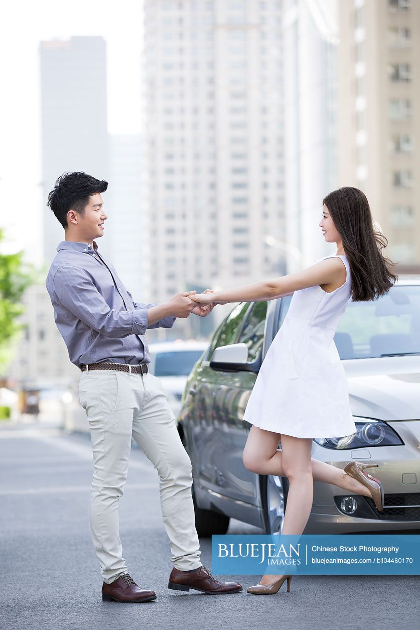 Happy young Chinese couple and car