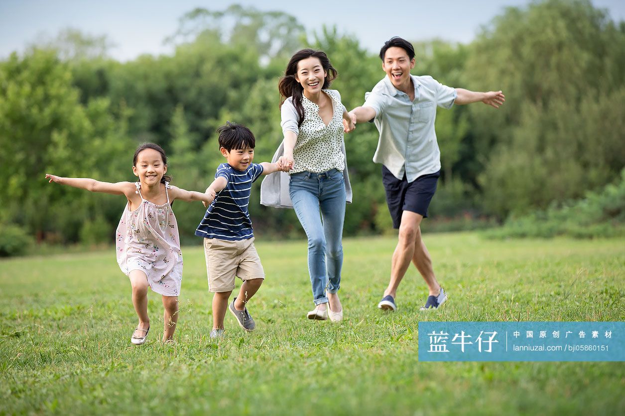 快乐年轻家庭在草地上奔跑