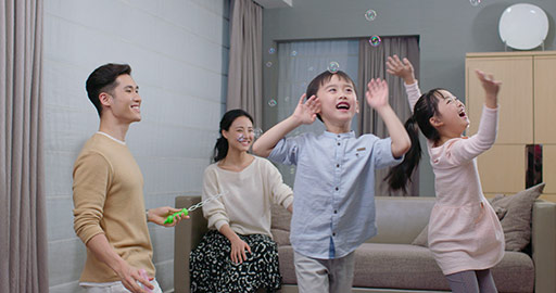 Young family playing with bubbles in living room,4K