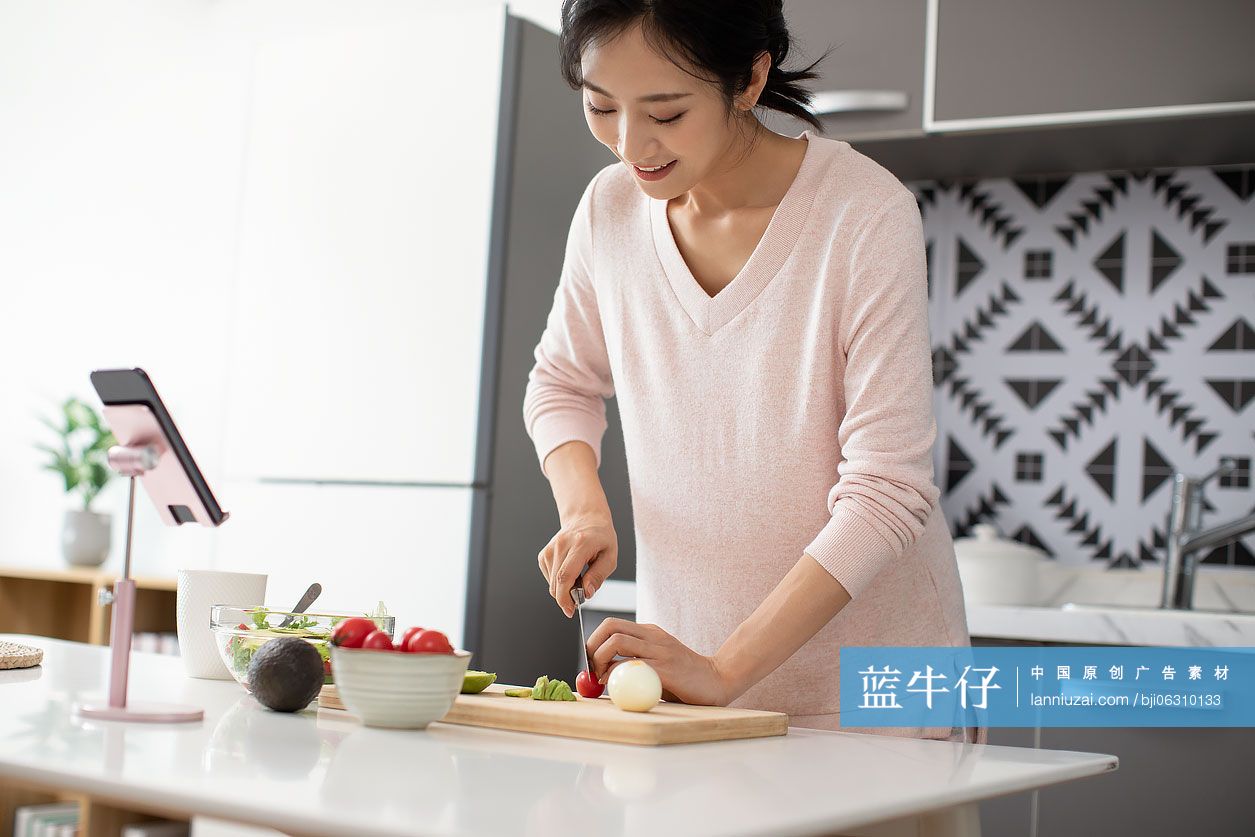 快乐年轻女士在厨房做沙拉