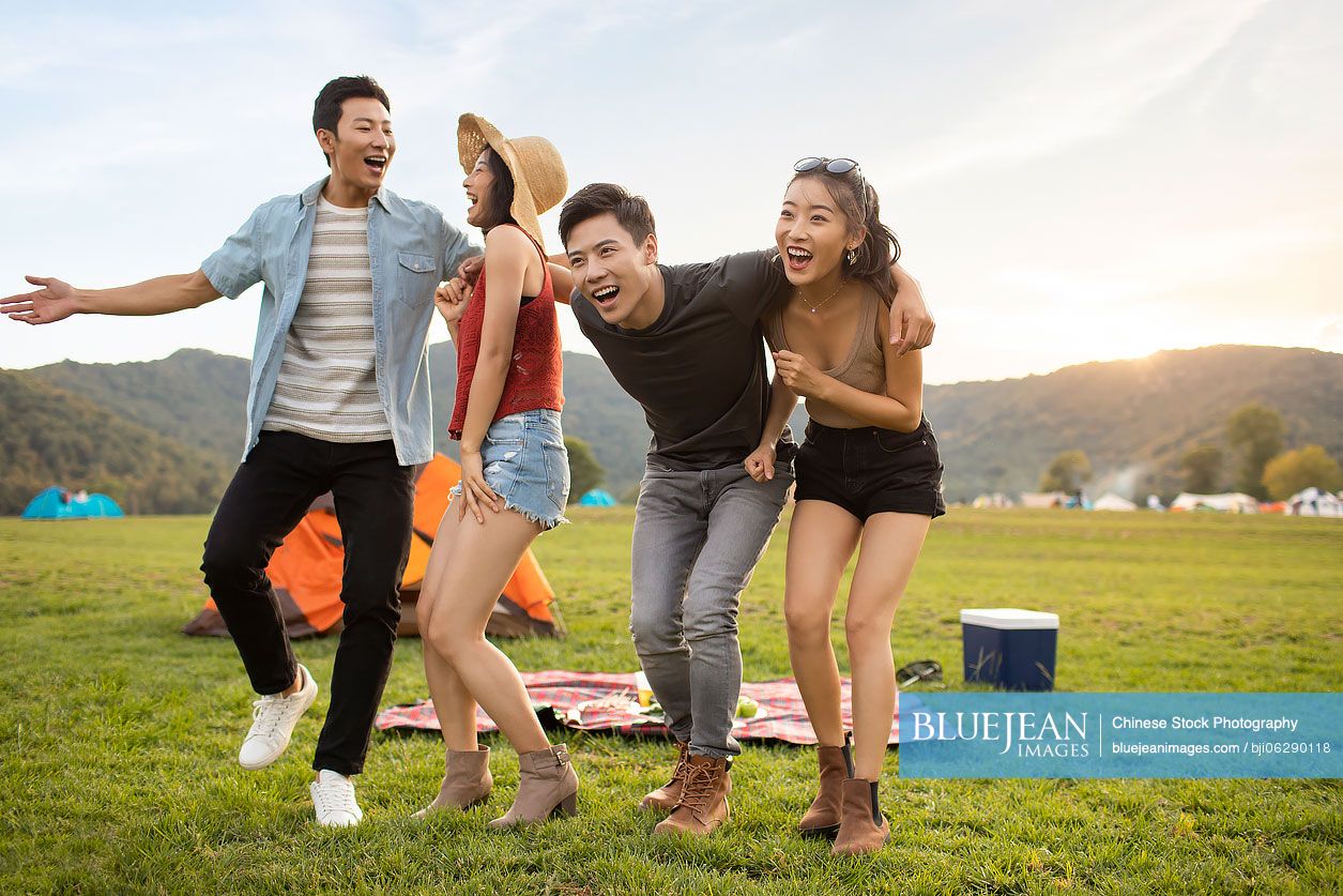 Happy young Chinese friends having a picnic outdoors