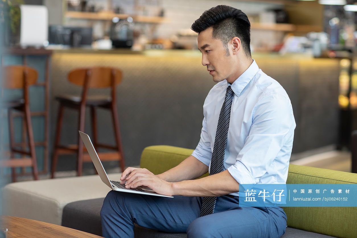 商务男士在咖啡馆使用笔记本电脑工作