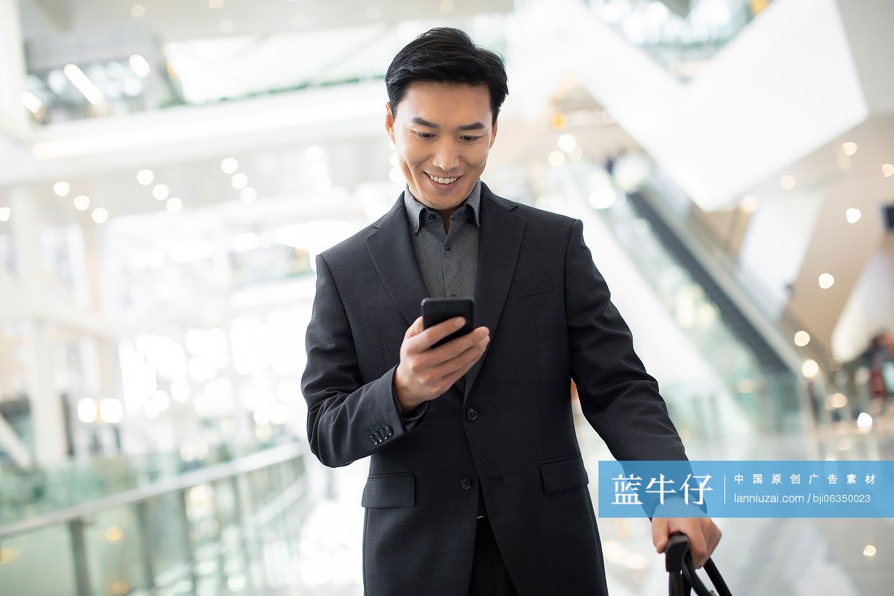 成功商务男士在机场使用手机