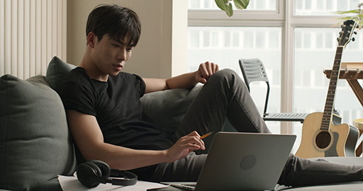 Young Chinese man composing music at home,4K