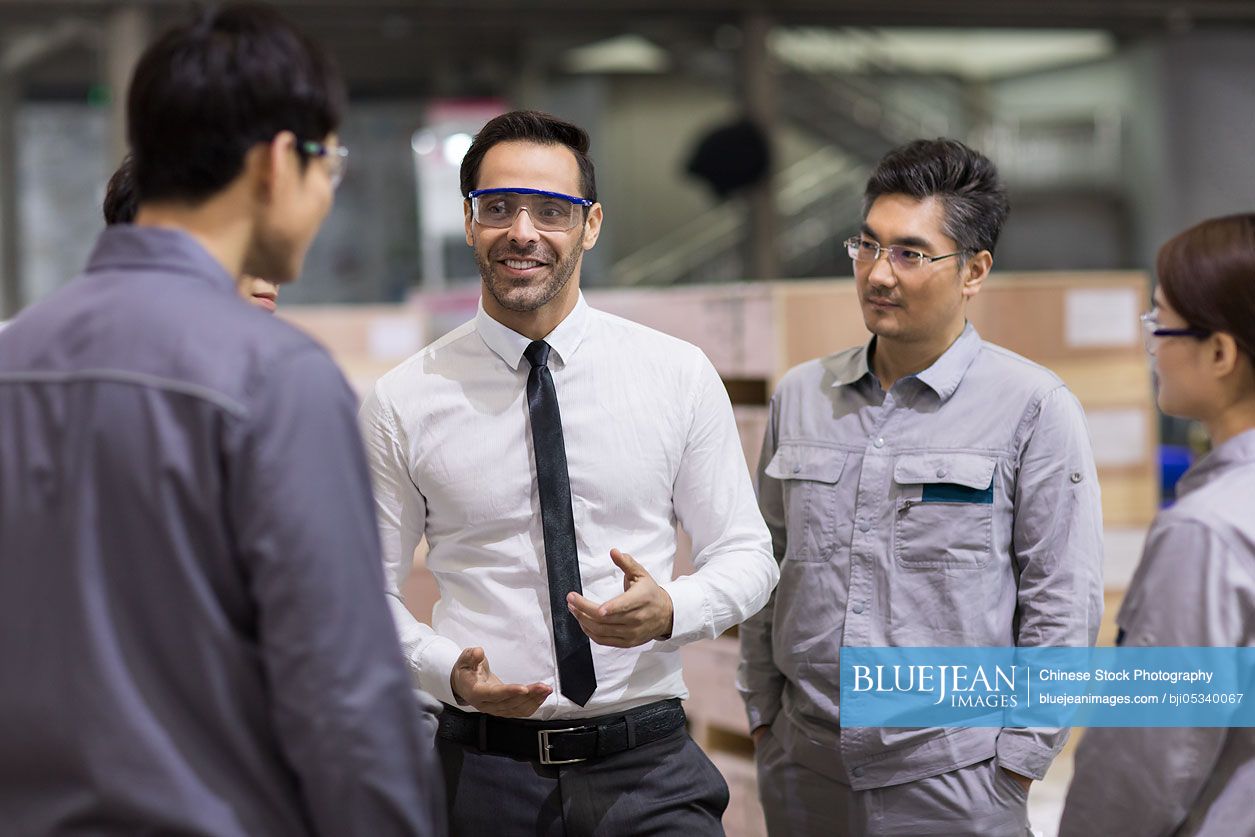 Businessman and engineers talking in the factory