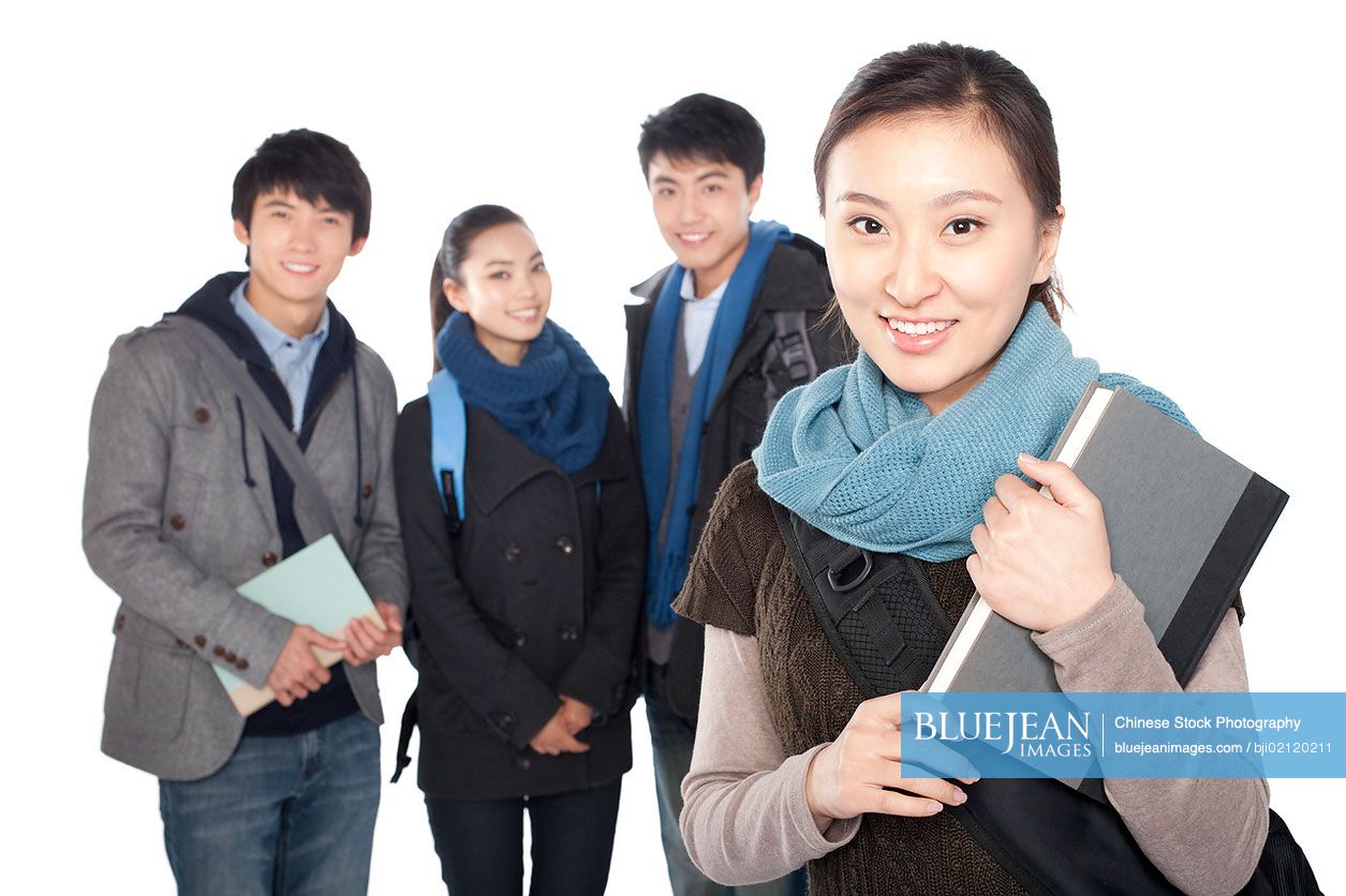 Female Chinese student smiling in the foreground with her friends smiling the background, white background