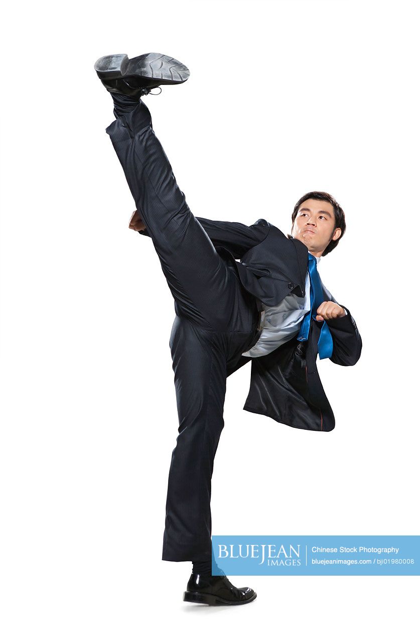Chinese businessman doing a karate kick