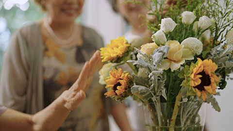 Happy senior Chinese friends arranging flowers together,4K