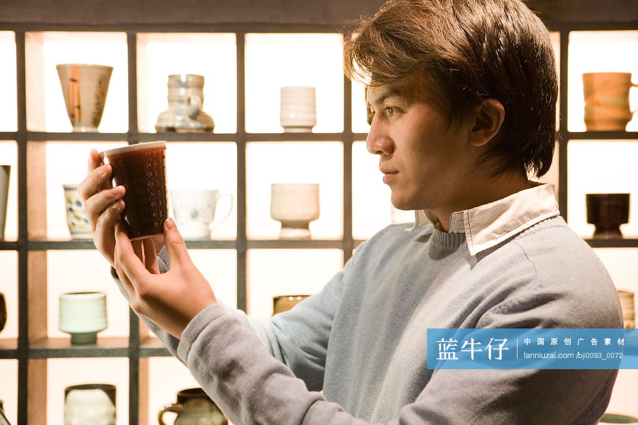 年轻男子挑选杯子