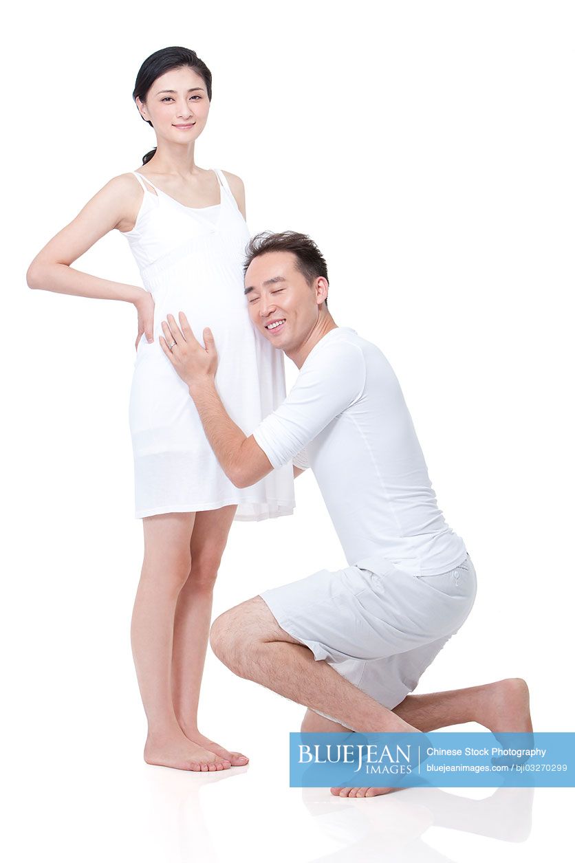 Cheerful Chinese man listening to the fetal heartbeat