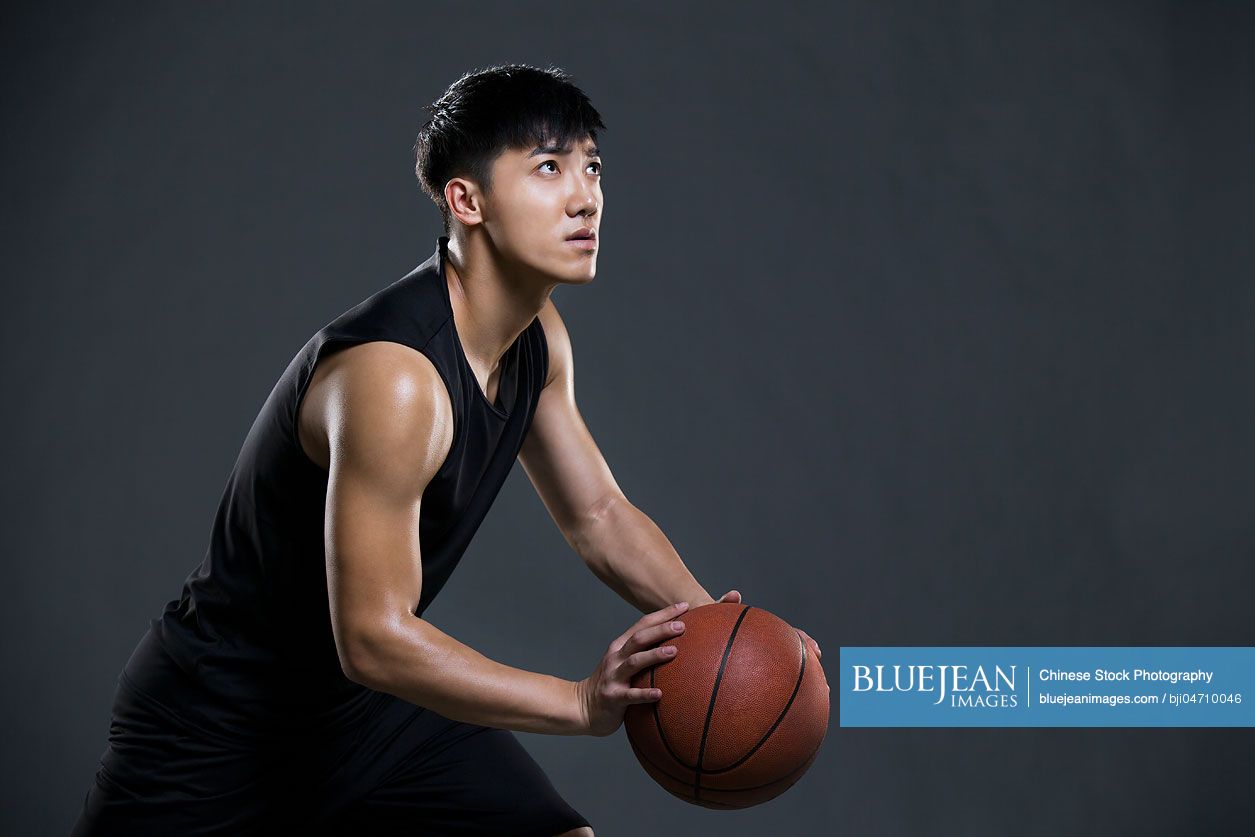 Young Chinese man playing basketball