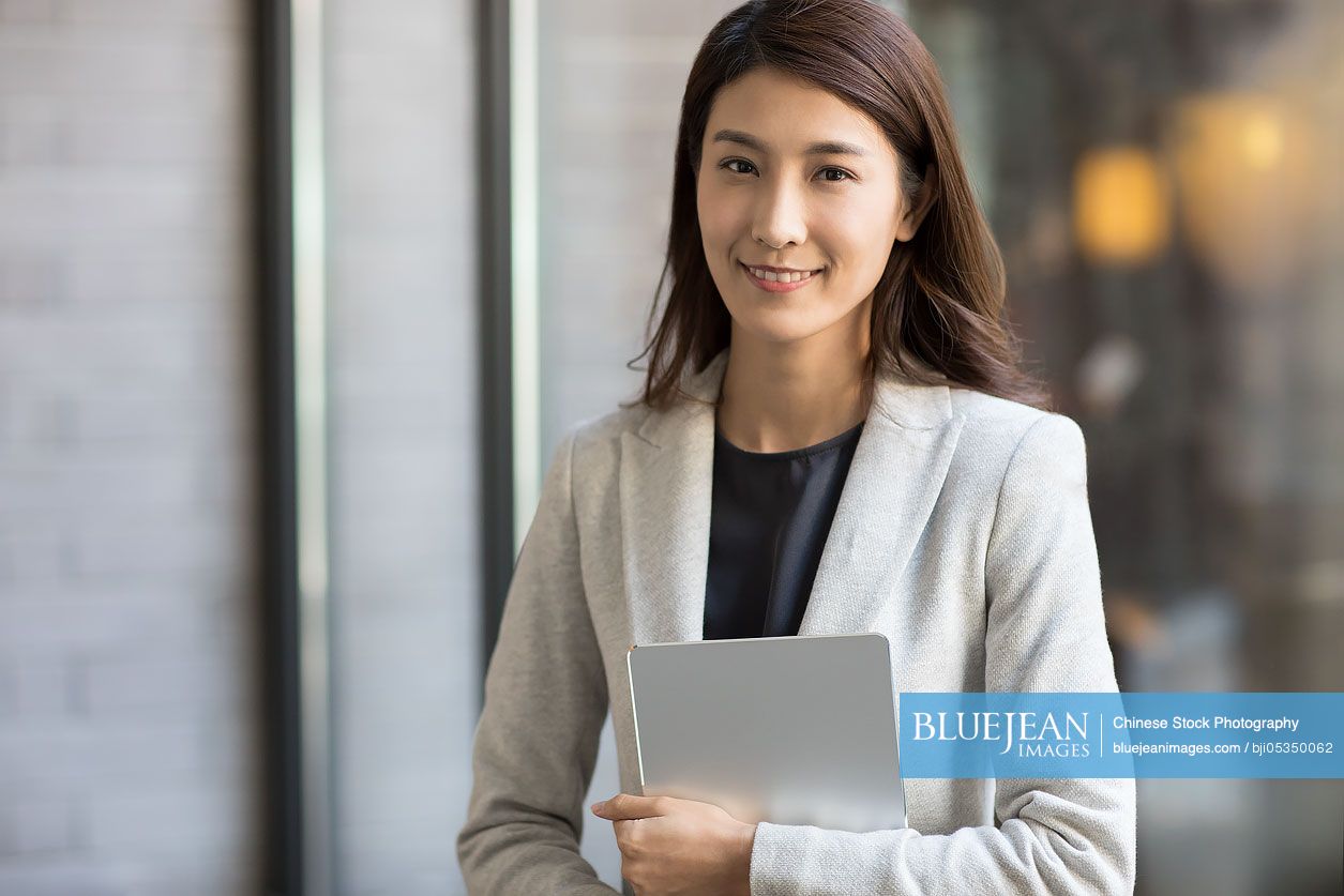 Young Chinese businesswoman holding a digital tablet