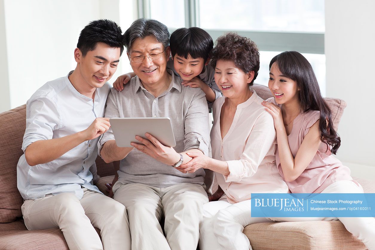 Happy chinese family looking at photo album high res stock photo for