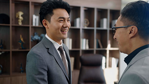 Successful Chinese business people shaking hands in office