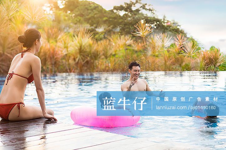快乐的年轻家庭在泳池里嬉戏