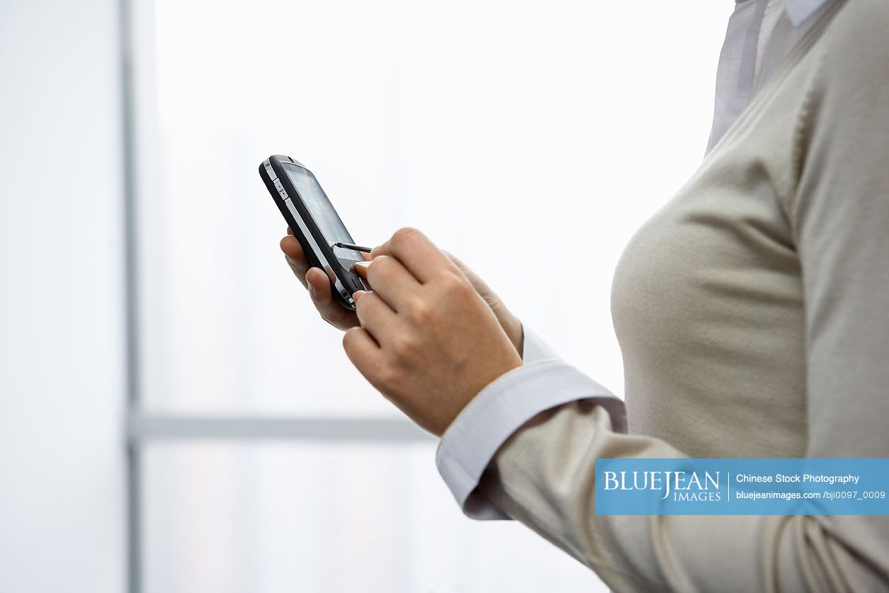 Chinese Businesswoman In Office Using Electronic Organizer High res chinese-businesswoman-in-office-using-electronic-organizer-high-res