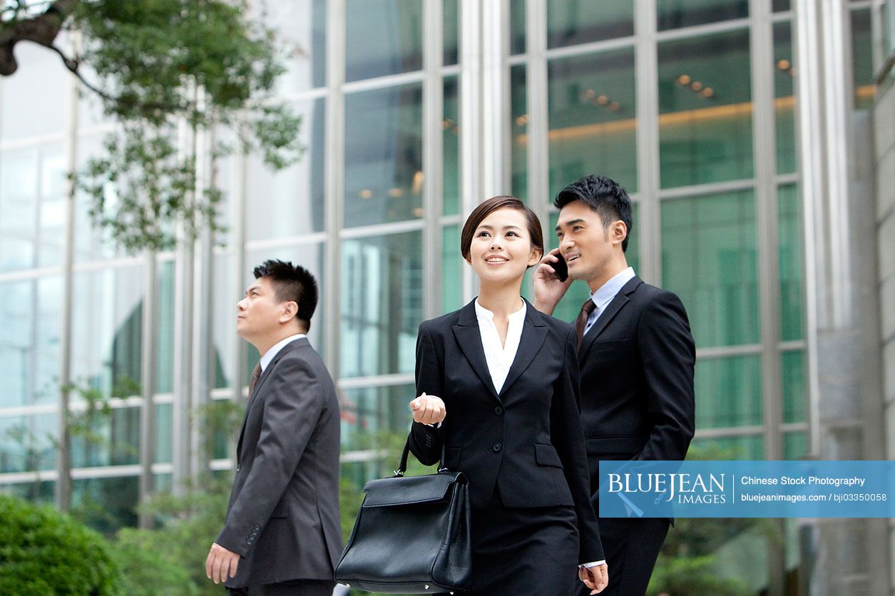 Cheerful Chinese office workers on the move outdoors, Hong Kong