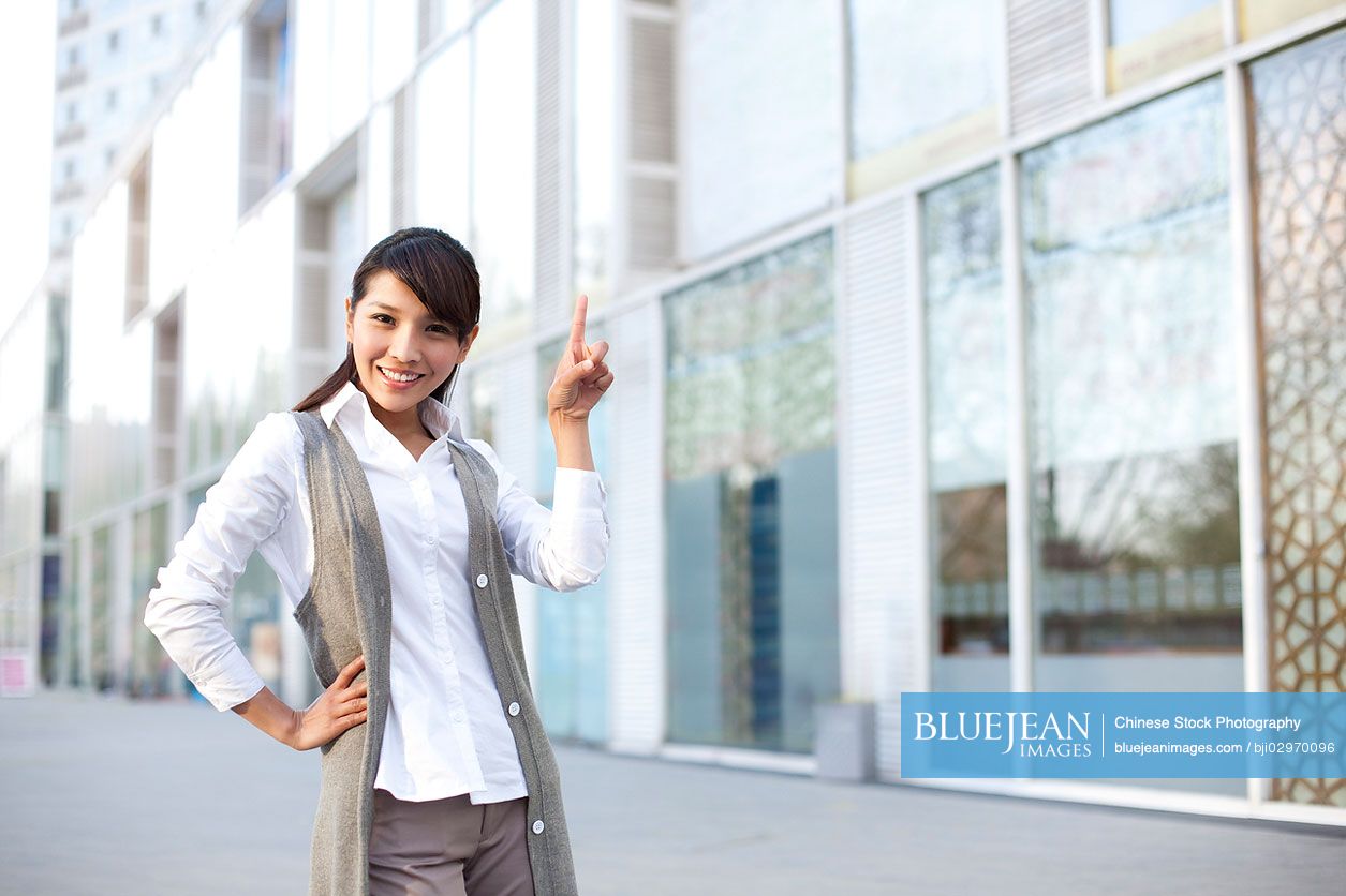 Young Chinese businesswoman pointing up