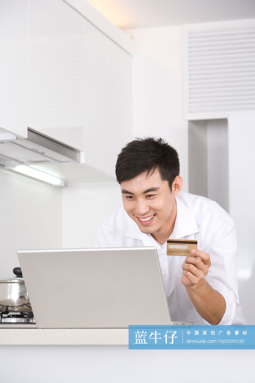 青年男子在厨房上网购物