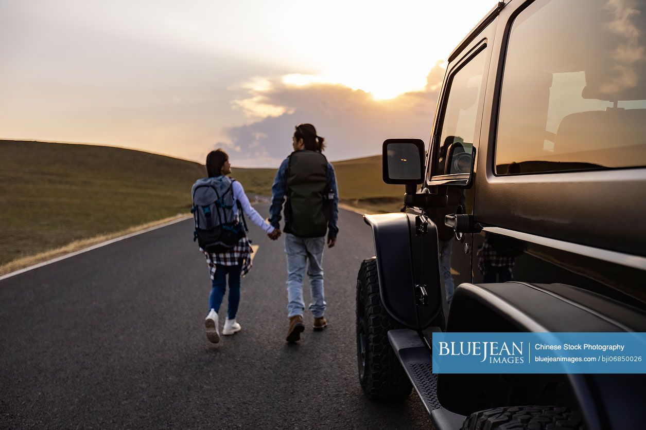 Happy Chinese couple enjoying road trip