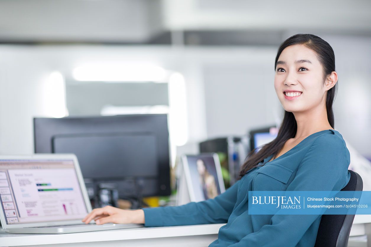 Young Chinese businesswoman thinking in office