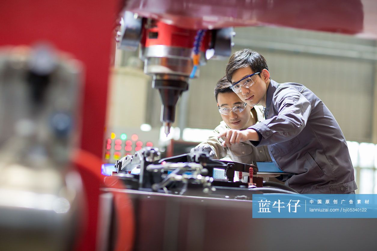 年轻工程师在工厂检查机器