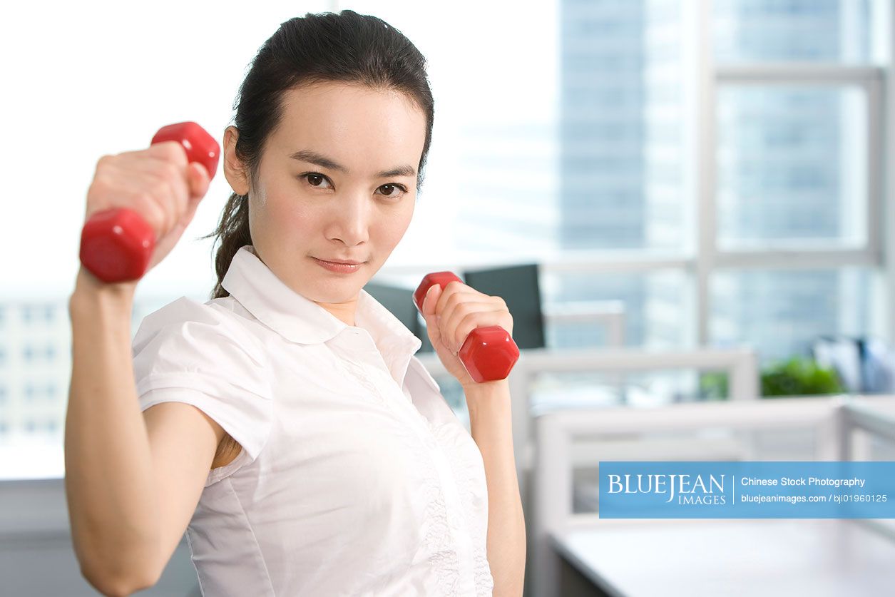 Chinese office worker working out in the office