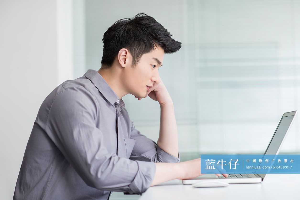 年轻商务男士在办公室使用笔记本电脑