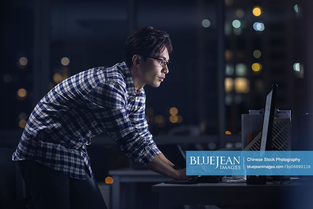 Chinese IT worker working in office at night