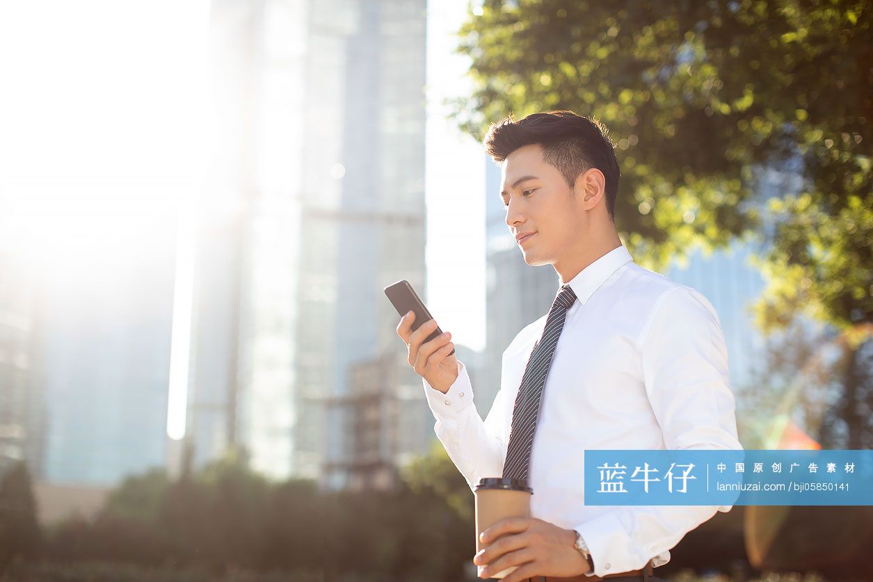 自信的年轻商务男士使用手机