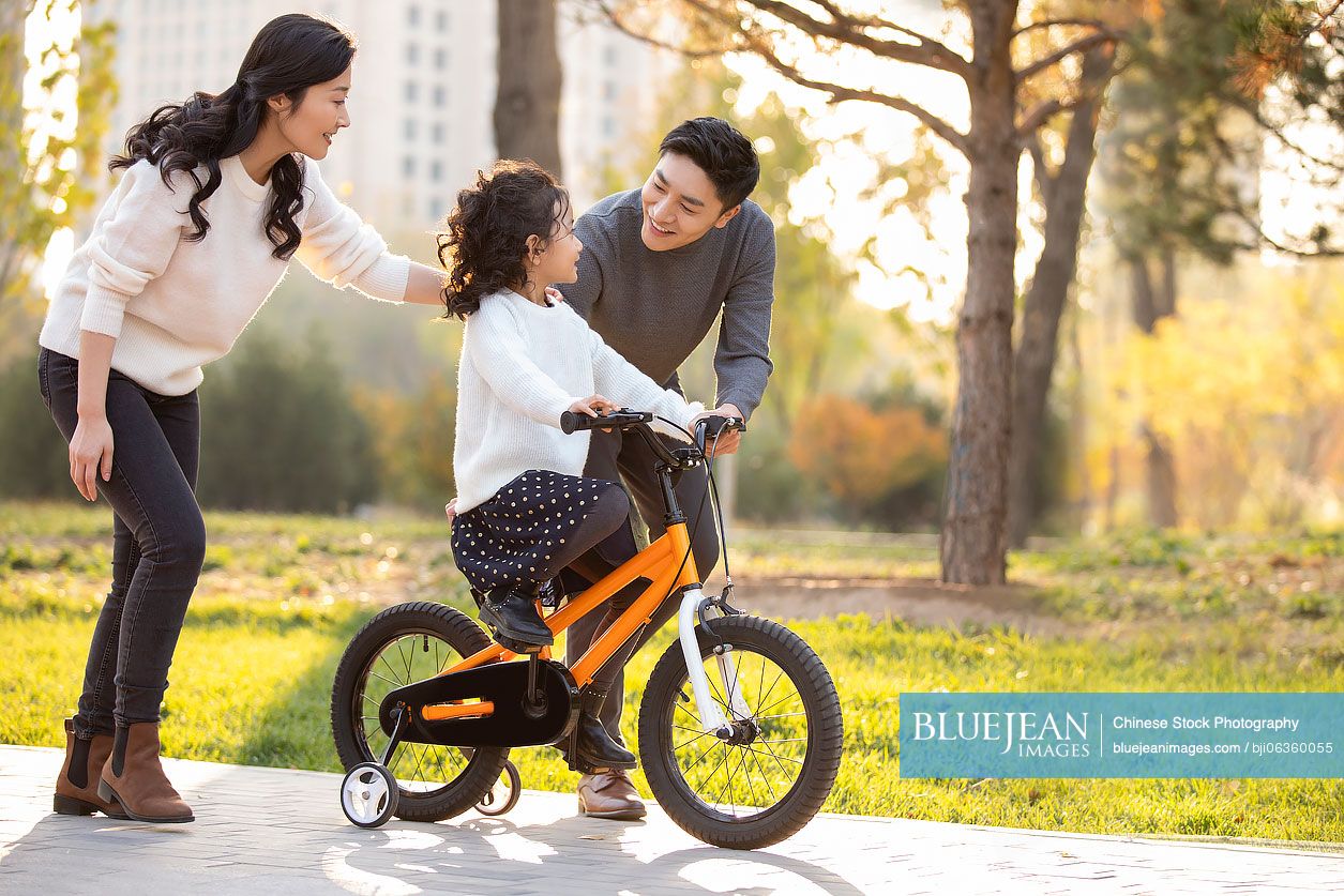 Chinese parents teaching child how to ride bike