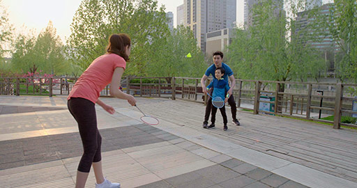 Happy young Chinese family playing badminton in park,4K