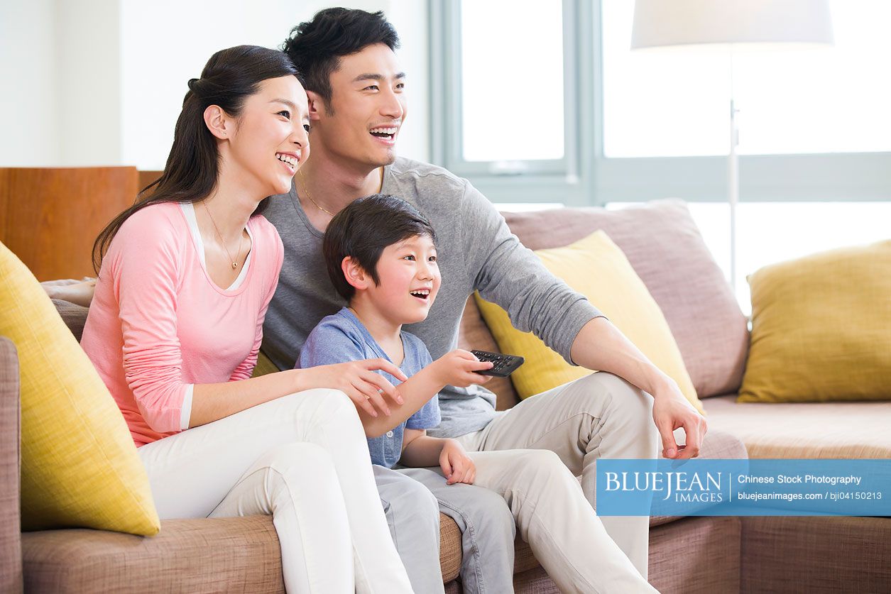 Happy Chinese family watching TV