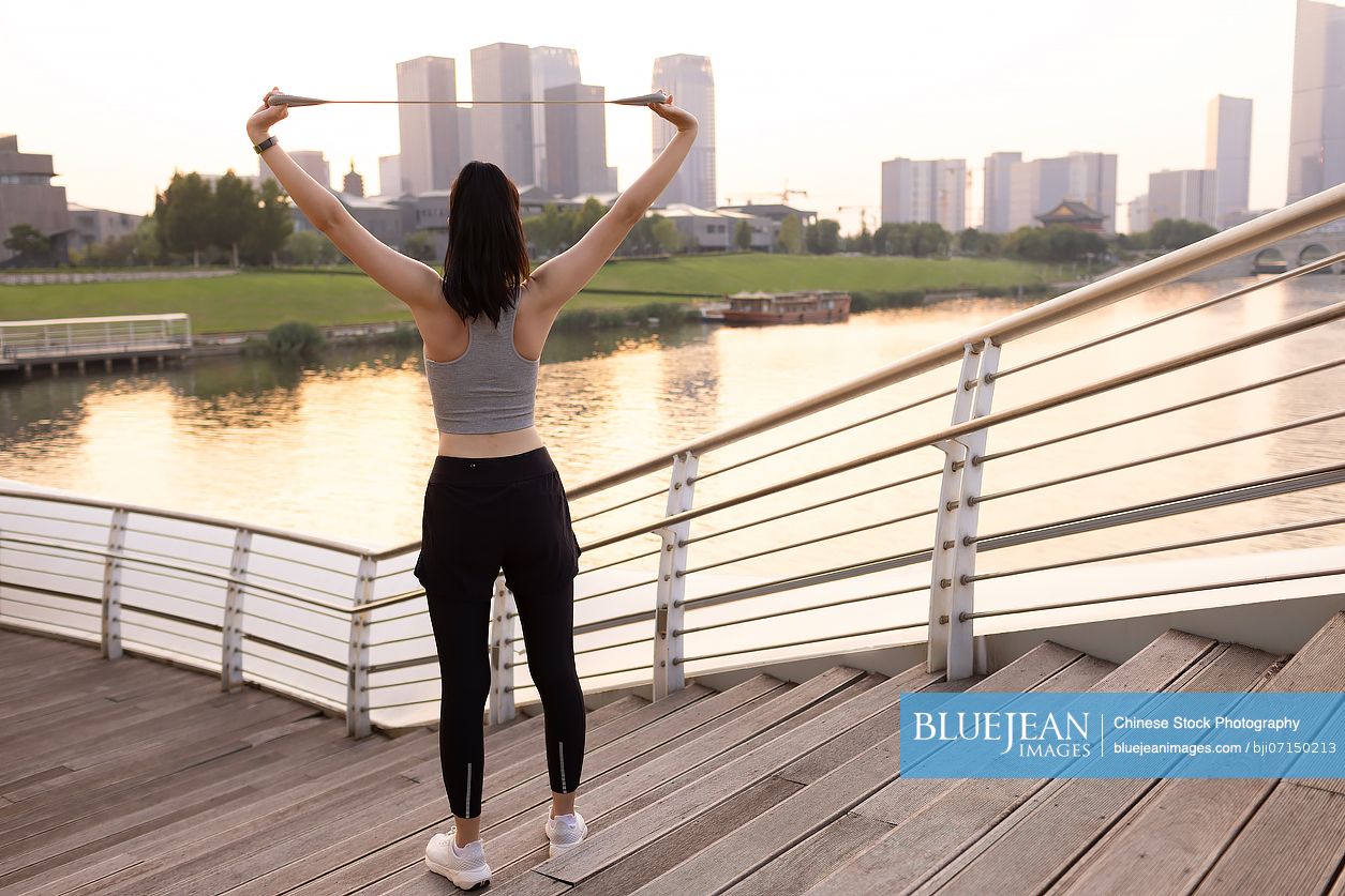 Young Chinese woman exercising with resistance band