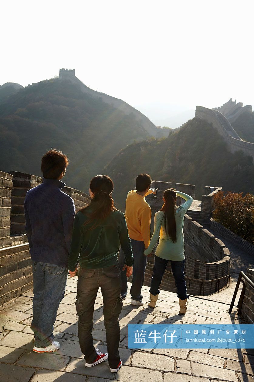 四个年轻人正在长城上远眺