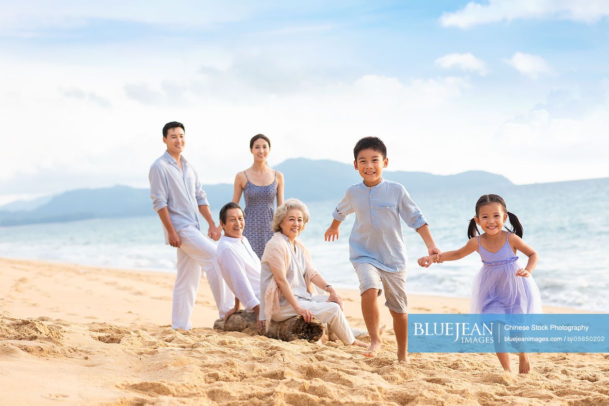 Happy Chinese family having fun on beach