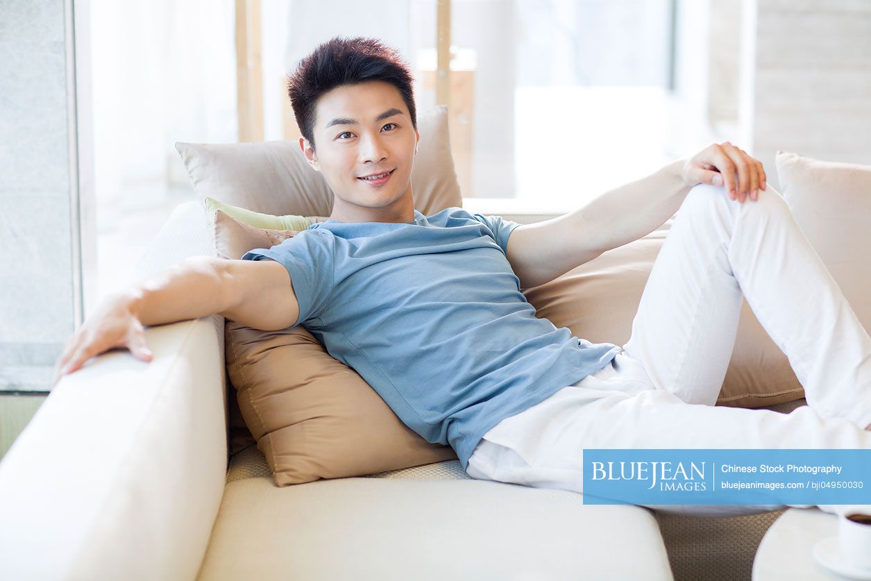 Young Chinese man relaxing on the sofa