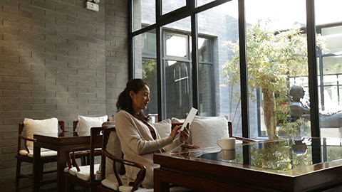 优雅的成熟女士在咖啡店使用平板电脑
