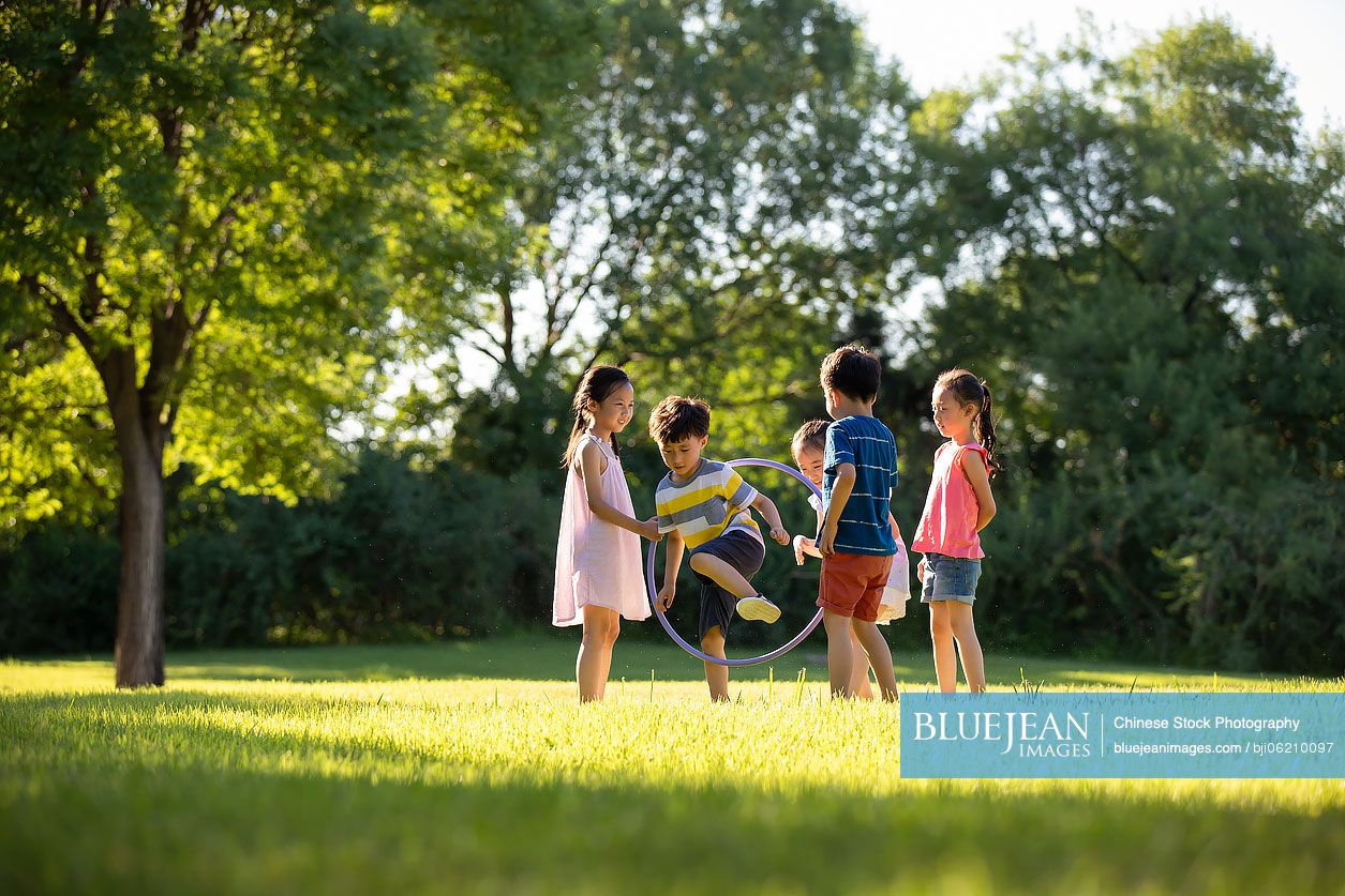 Happy Chinese children playing on meadow