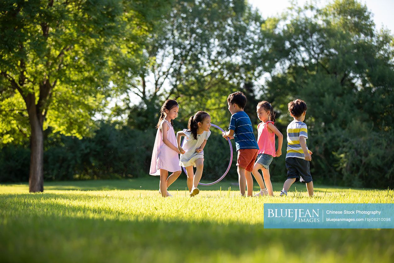 Happy Chinese children playing on meadow