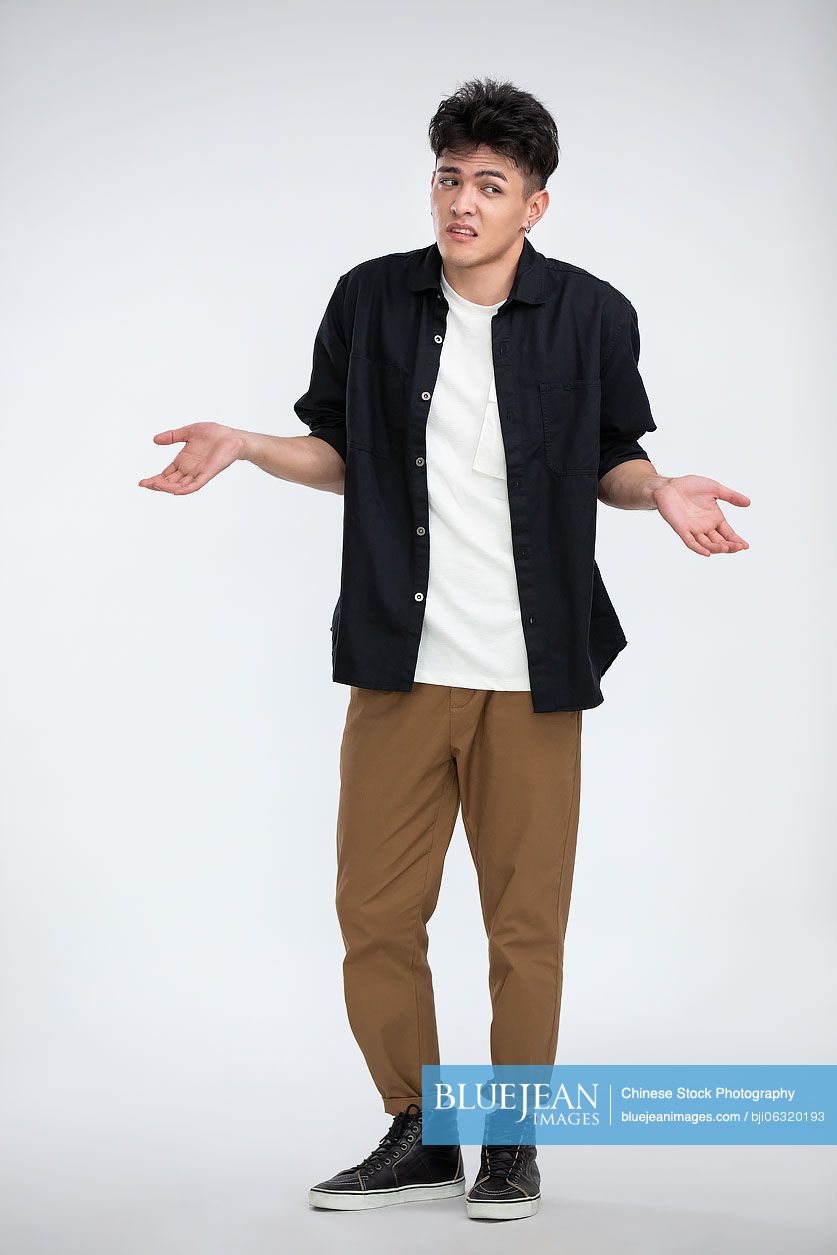 Young Chinese man shrugging