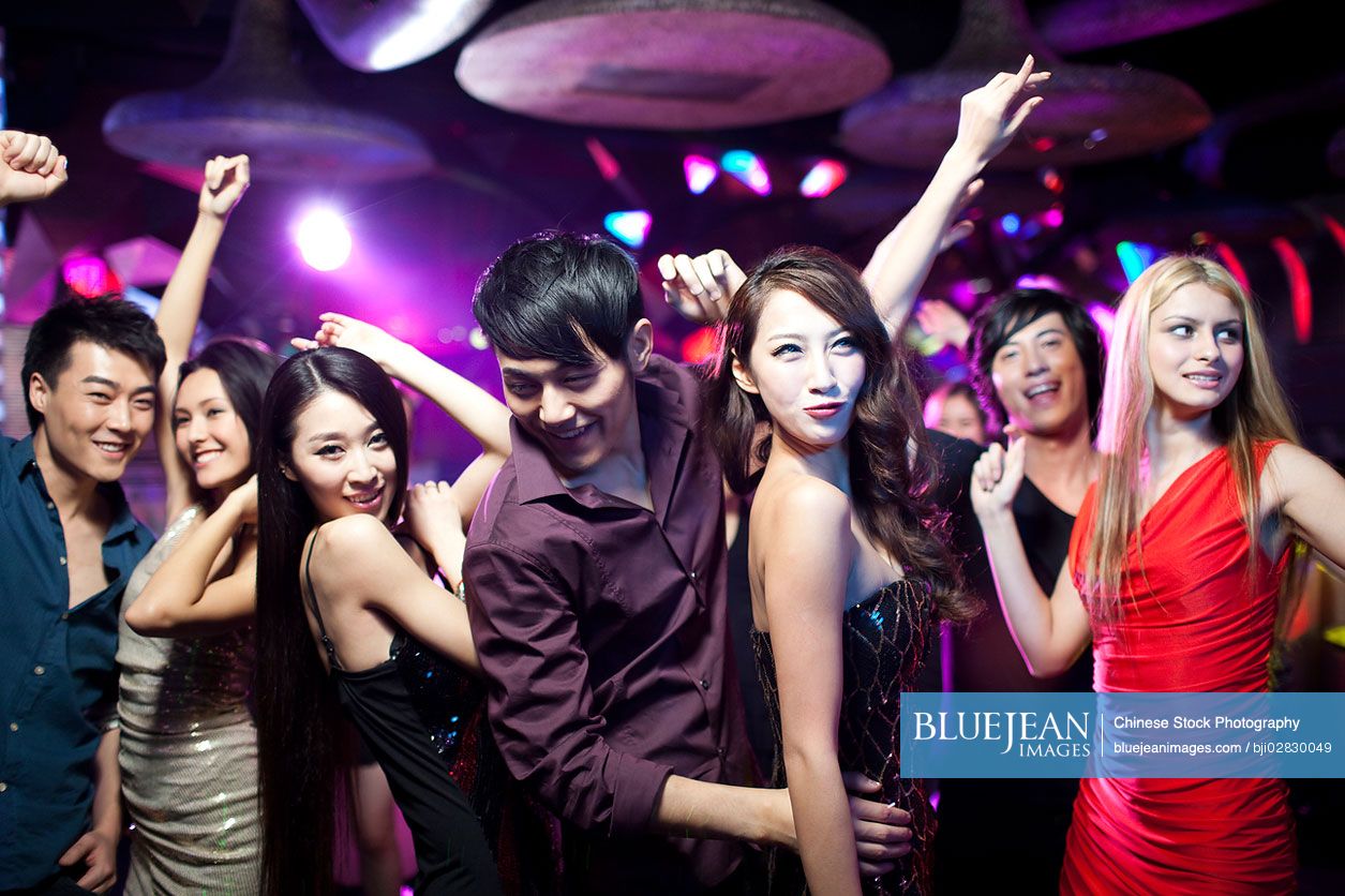 Stylish young Chinese dancing in nightclub