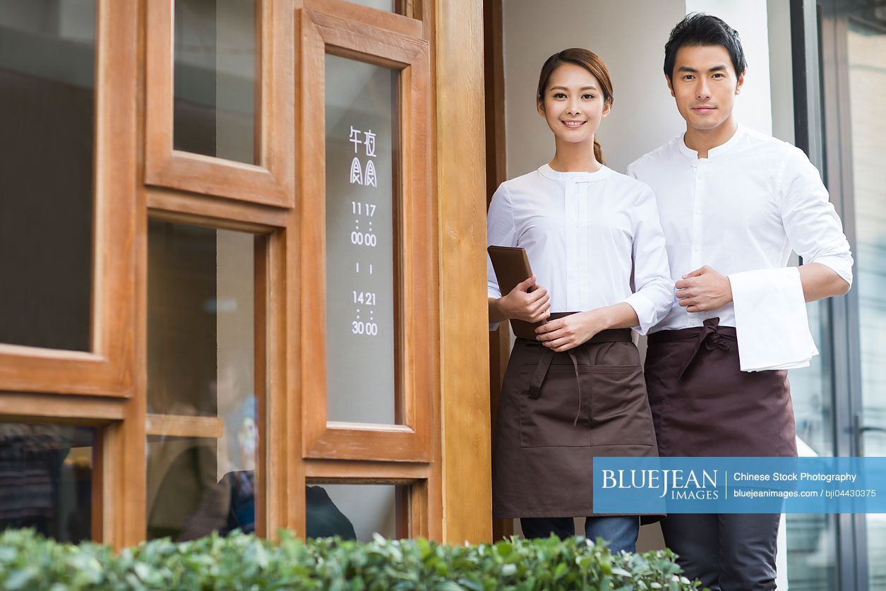 Chinese wait staff standing in restaurant doorway