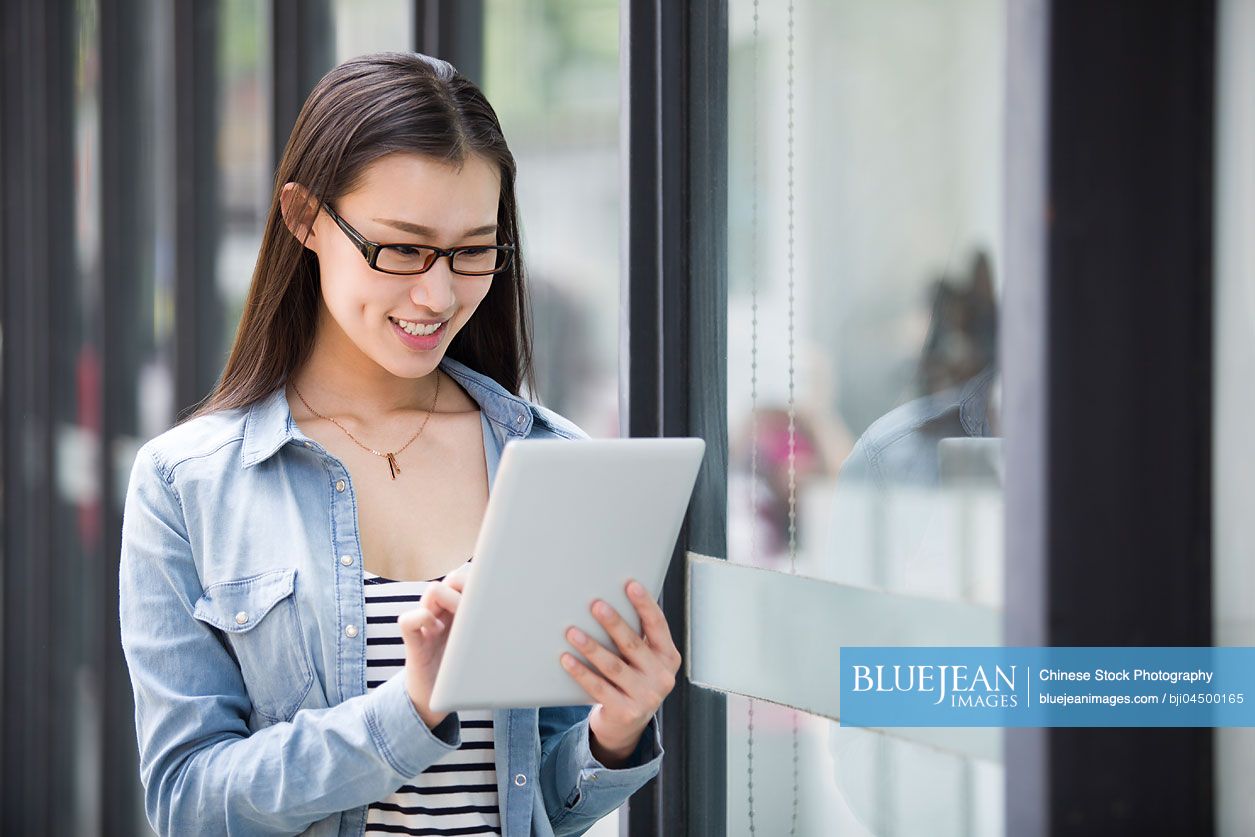 Young Chinese woman using digital tablet