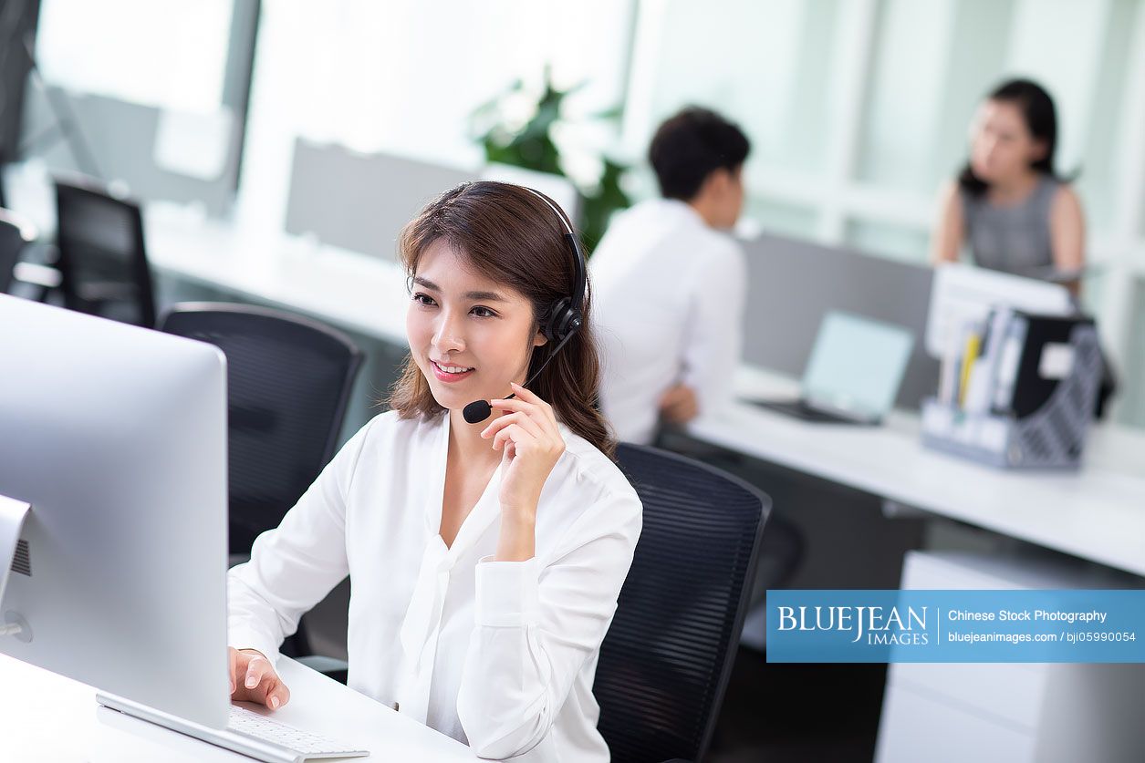 Young Chinese call center agents working in office