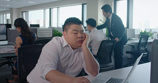 Young Chinese businessman yawning at work,4K